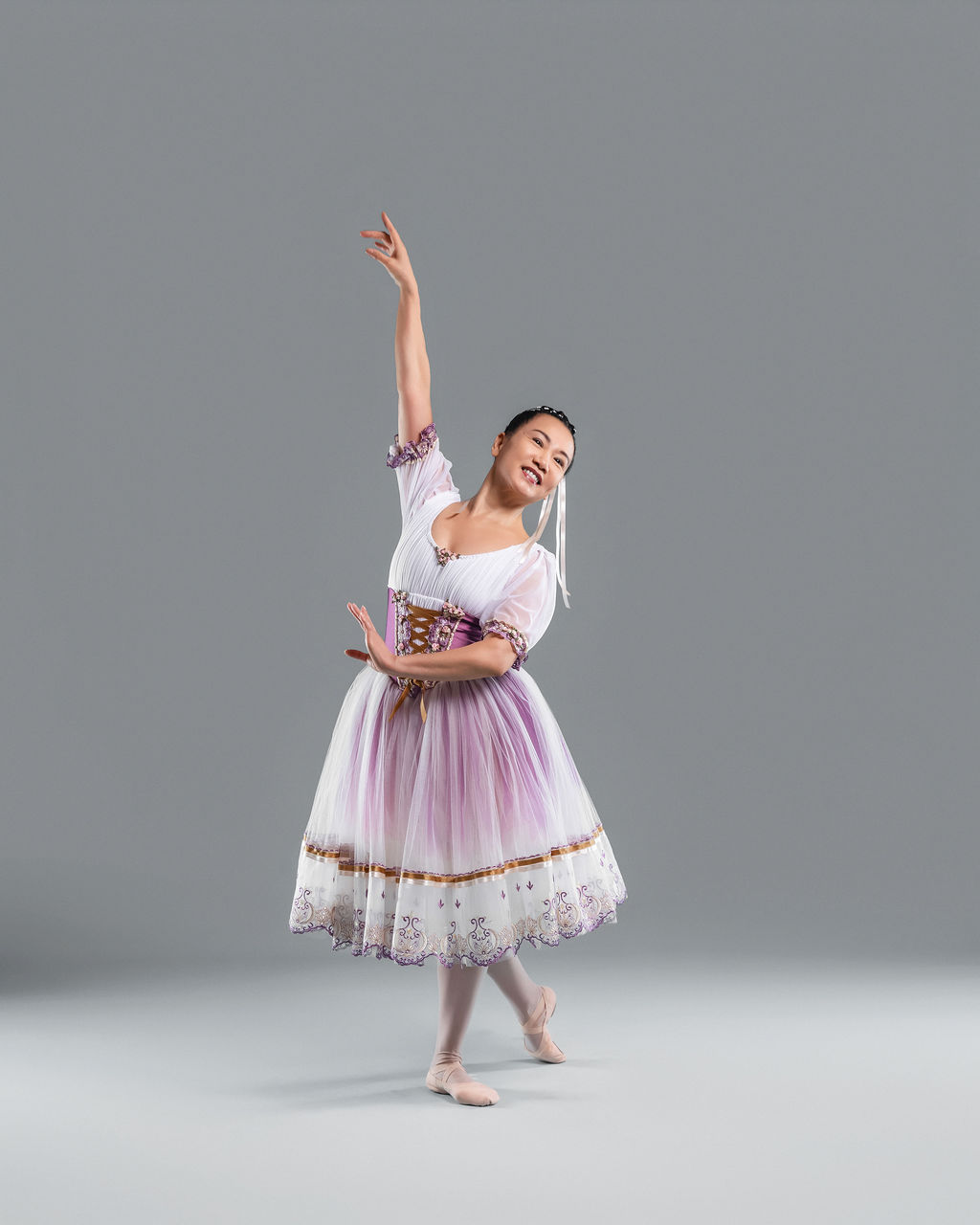 Dancer twirling in a white and lavender folk dress