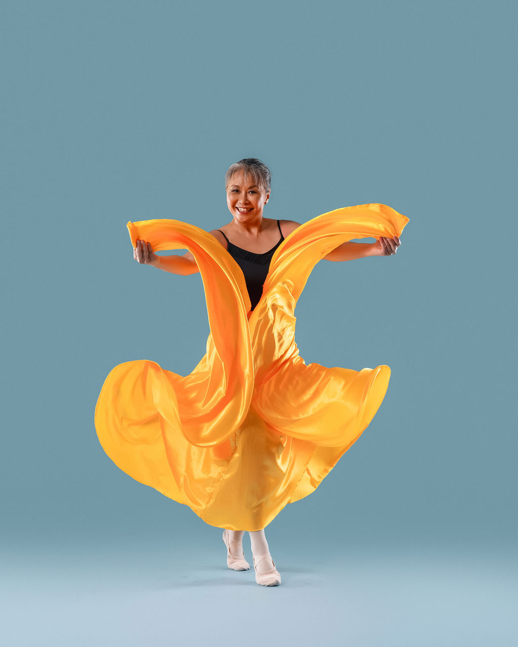 Dancer twirling in flowing orange fabric
