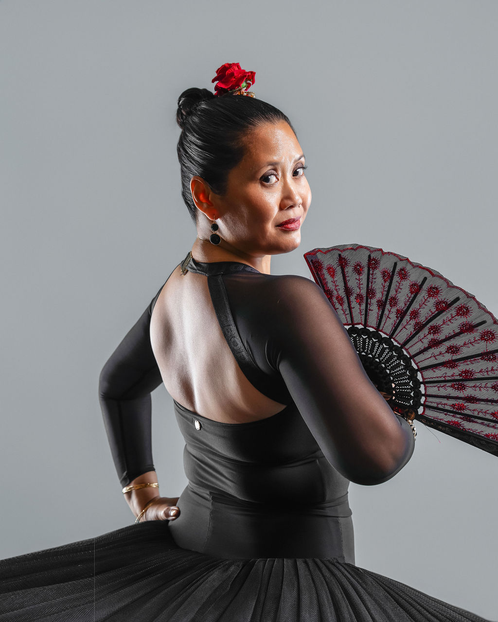 Dancer in a black costume with a fan