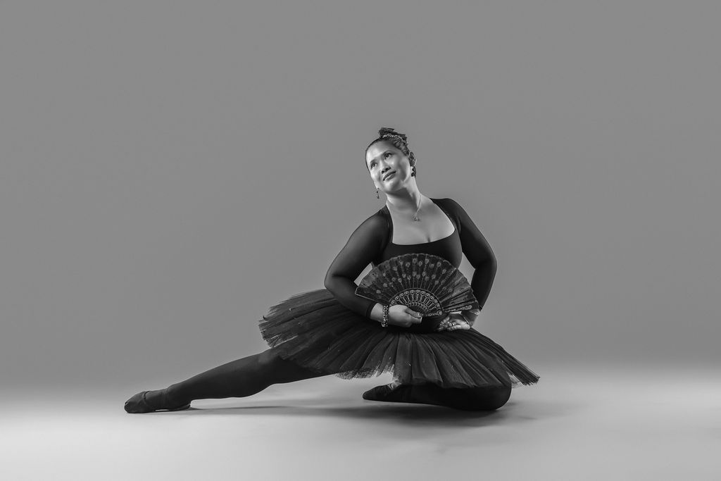 Dancer in a black tutu, dramatic seated pose