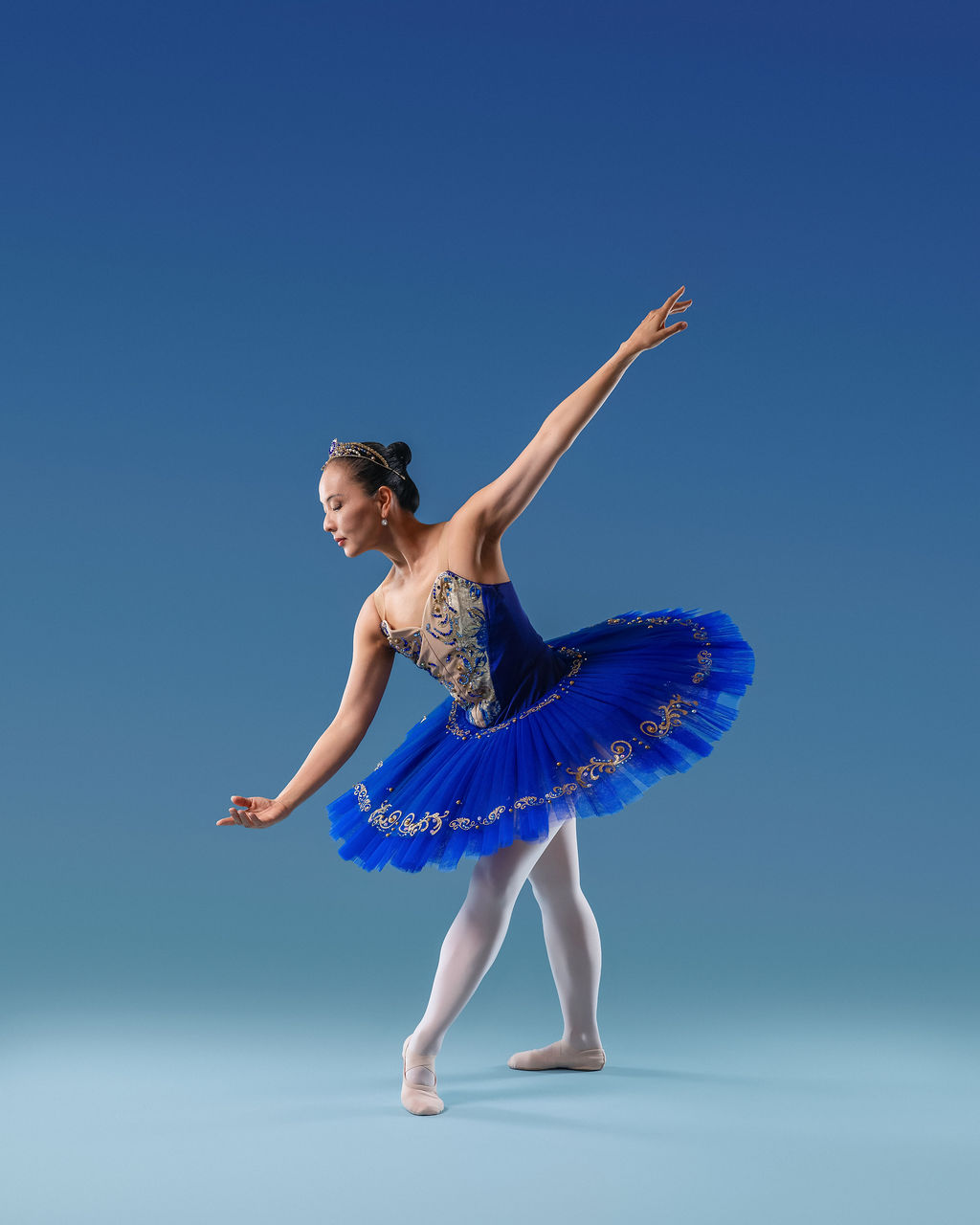 Dancer in a blue tutu, elegant pose on pointe