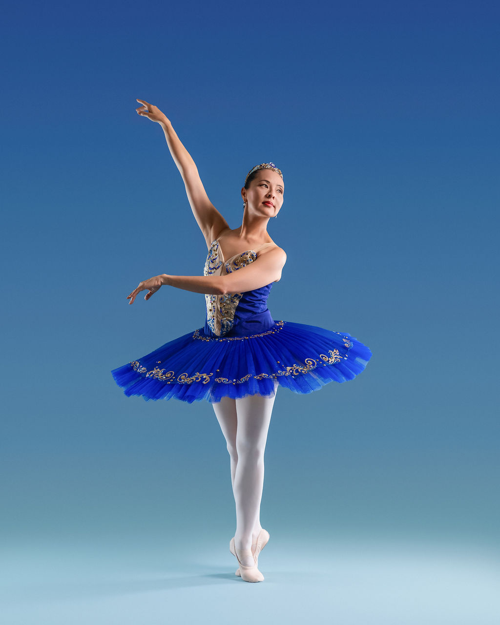 Dancer in a blue tutu with arm raised