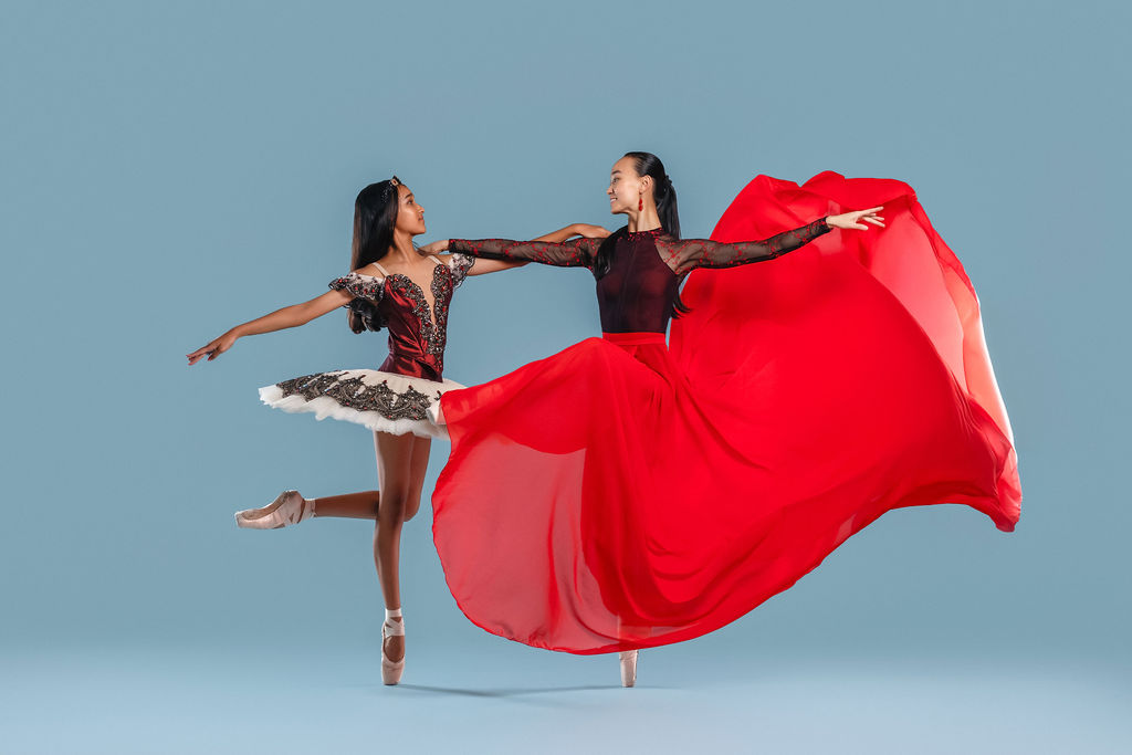 Two dancers with flowing red fabric