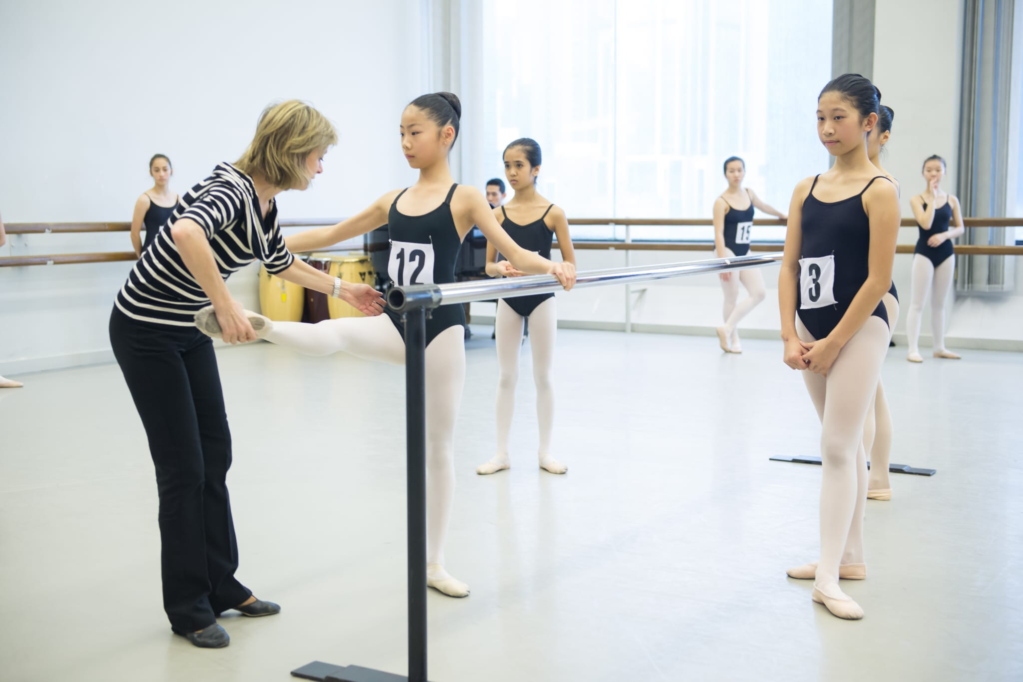 A master teacher coaching audition candidates at the barre