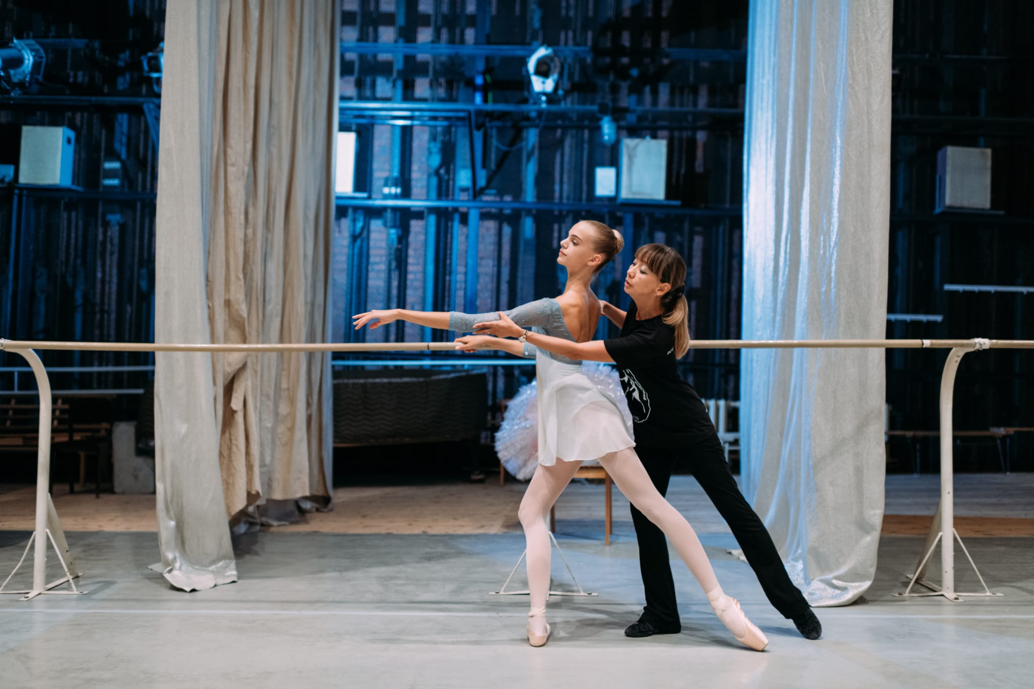 A teacher coaching a dancer backstage before a performance